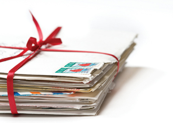 Stack of love letters tied with a red ribbon