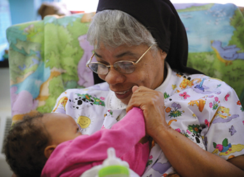 Sister Brenda Cherry, O.S.P. rocks Azariah Yarbrough-Hutchins to sleep. Sister Brenda is director of the Mt. Providence Child Development Center.