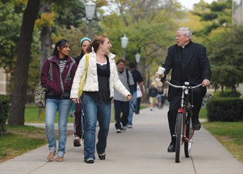 Holy Cross Father Joseph H. Carey, C.S.C., chaplain for the Alliance for Catholic Education, greets students at the University of Notre Dame.