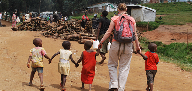 Erin McDonald walks with children at a Congolese refugee camp
