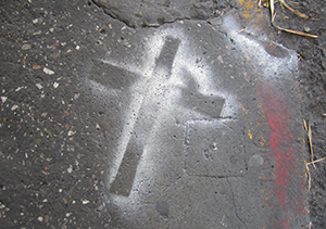 spray painted cross on a sidewalk