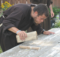 Brother Joshua van Cleef, O.F.M. sands a picnic table for Our Lady Queen of Peace Parish in Arlington, Virginia.