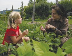 Sister Raffaella Petrini, F.S.E. talks with a young friend about gardening.