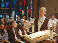 Sister Marjorie Robinson lights candles for Mass. Carmelite prayer life includes daily celebration of the Eucharist.