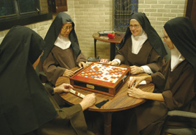 Carmelites have two hours of recreation each day. Sister Marianna So (center left) enjoys a game of Scrabble with other sisters.