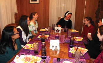 Sister Colleen (head of table) eating with participants during a discernment retreat.