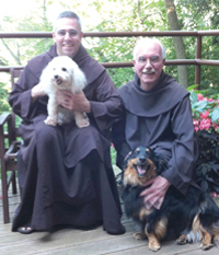 Father michael and Father Phillip Thomas, O.C.D. with canine friends.