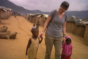 erin McDonald walks with two girls in a camp for Congolese refugees.