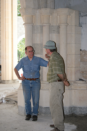 Father Thomas Davis, O.C.S.O., a former abbot, discusses the progress of the building with master stonemason Frank Helmholz.