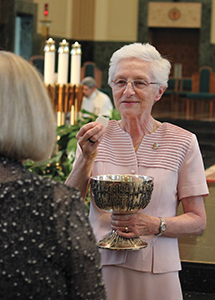 Joliet Franciscan Sister Dolores Zemont, O.S.F. distributes the Eucharist. Gospel living through prayer and action is a key part of Franciscan spirituality.