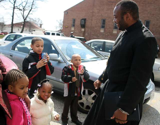 Father Anthony Anichukwu, S.S.J talks with children after Mass
