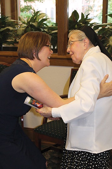 Walsh and Sister Rita Marie Bechel, F.S.P.A. share a hug 
