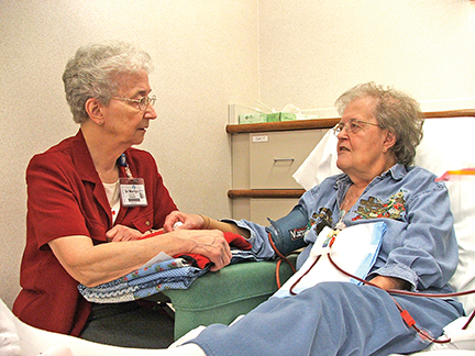 Hospital chaplain Sister Marilyn Herr, O.S.F. visits the sick, a corporal work of mercy. 