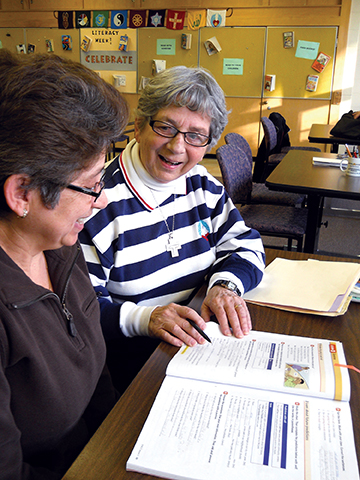Sister Margaret LeClaire, S.S.S.F. helps a student improve her literacy skills