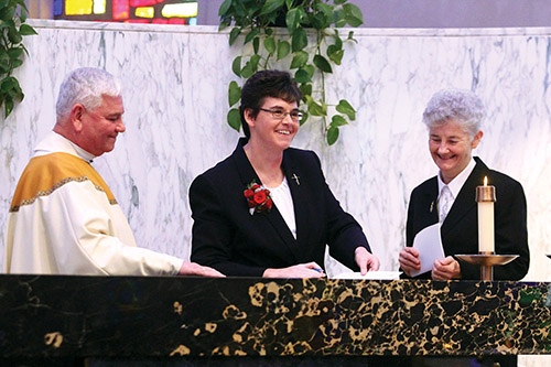 The final vows ceremony for Sister Kimberly Kessler, C.S.R. (center) evokes smiles all around, including from Father Timothy Judge and Sister Anne Marie Haas, C.S.R., province leader for the Sisters of the Redeemer.