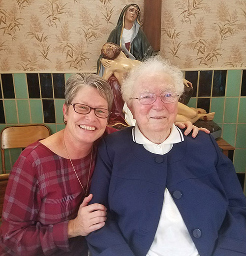 Sister Renée Daigle, M.S.C. gives a hug to fellow Marianite Sister Marie Renée Moreau.