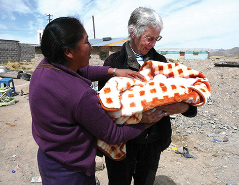 Sister Jean Faustman, S.S.J. returns to her former ministry site in Yauri, Peru each summer to live among and minister to the people. Here, she admires an infant whose family she assisted.