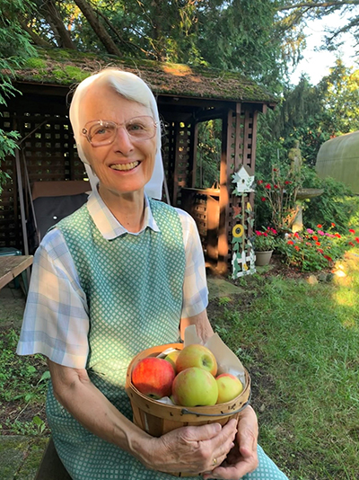 Sister Grace Ellen Urban, O.S.F. holds apples gathered from trees on the property of her community, the Sisters of St. Francis of Sylvania, Ohio. 