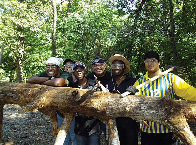 Novices with  the Missionary Oblates (O.M.I.) remove the invasive species of honeysuckle from Missionary Oblates’ Woods, a nature preserve in Godfrey, Illinois.