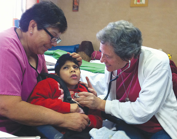 Gildea (right) provides medical care to a child with special needs at the clinic she founded in Anapra, Mexico.