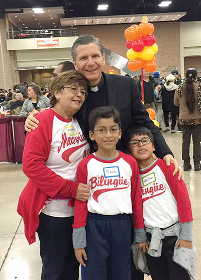 García-Siller posa con participantes de una gran Cena de Acción de Gracias que se celebra cada año en un centro de convenciones de San Antonio, Texas.