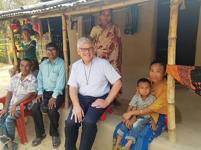 Brother Paul Bednarczyk, C.S.C. has tea with a family near Mariamnagar, Bangladesh.