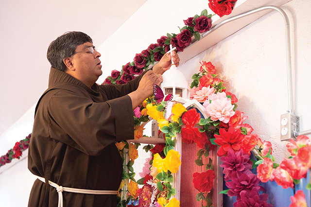 Father Ponchie Vásquez, O.F.M. repairs the cross on top of Our Lady of Lourdes Shrine in the village of Comobabi, Arizona.