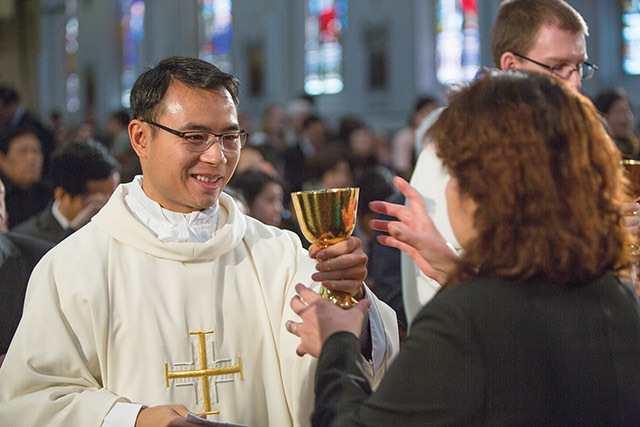 A newly ordained permanent deacon for the Archdiocese of Boston distributes Communion.
