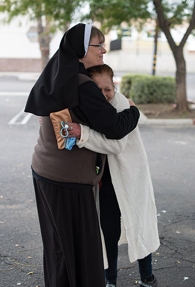 A Felician sister gives someone a hug. 