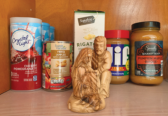 A pantry shelf sports a carving of the holy family as a reminder to pray for those who lack food.