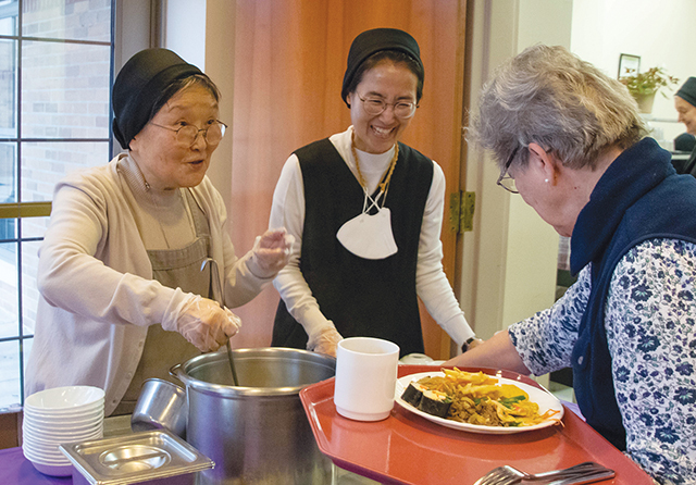 Sisters belonging to the Korea Province of Sisters of Charity of Seton Hill serve Korean food during a Lunar New Year celebration at the community’s motherhouse in Greensburg, Pennsylvania.
