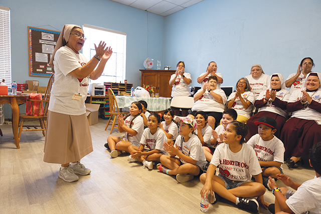Sister Dolores Avila, S.T.J. leads children in an activity. 