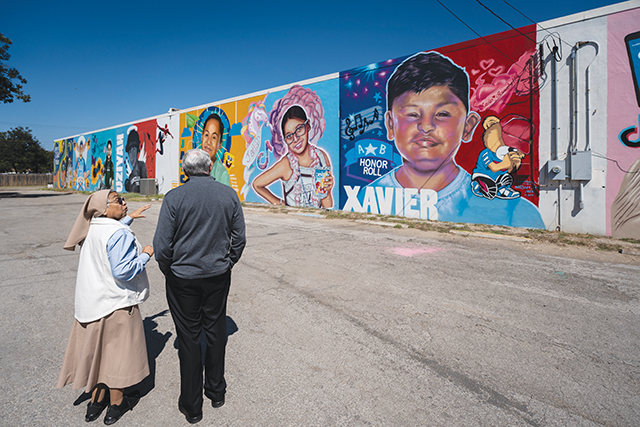 Sister Dolores Avila, S.T.J. and Catholic Extension President Father Jack Wall stand before murals of the 19 children and two adults killed by the Uvalde gunman.