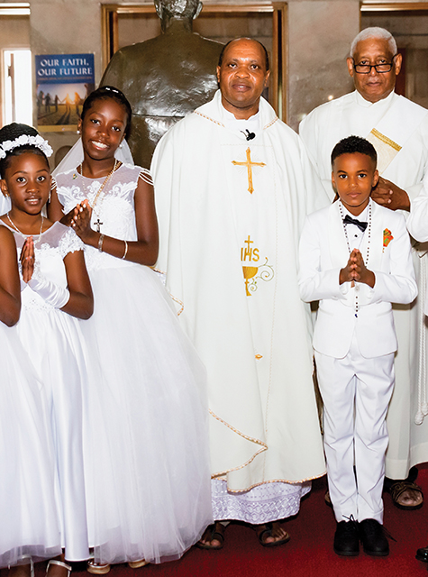 Munishi with a First Communion group at St. Edward Parish in Baltimore. 