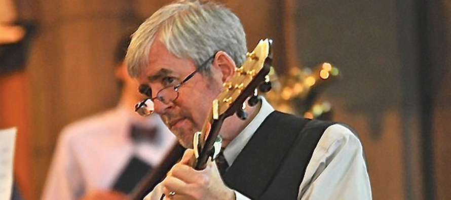 Composer Steve Warner playing guitar at liturgy