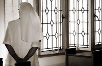 Nun gazing out window