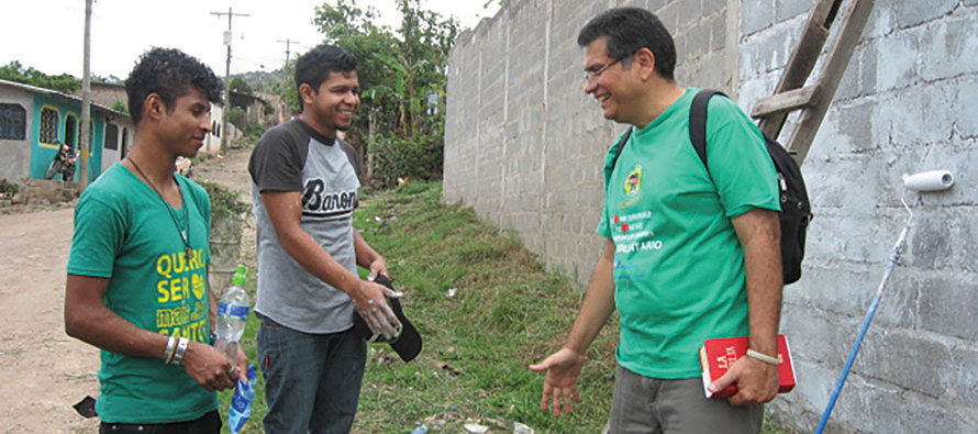 Zúñiga prays with youth who are about to paint a mural