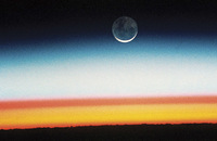This photo, taken from the Space Shuttle Columbia in 1992, shows a moonrise and sunrise from outer space. 