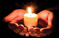 Cupped hands holding a candle