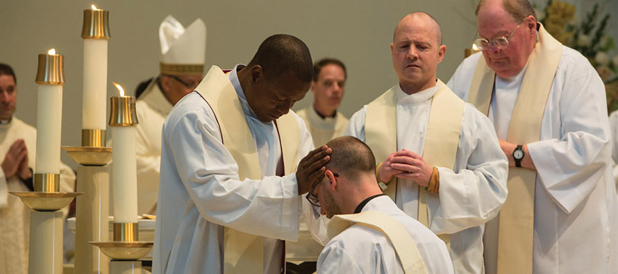 Father Paddy Gilger, S.J. receives blessings from fellow Jesuits during his ordination Mass.