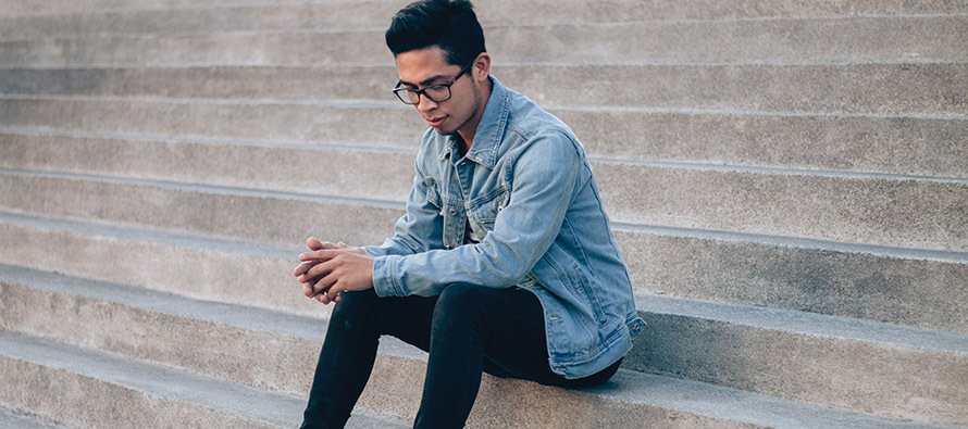 young man sitting on steps looking pensive