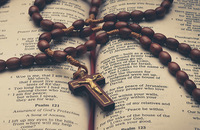 Rosary beads on an open Bible