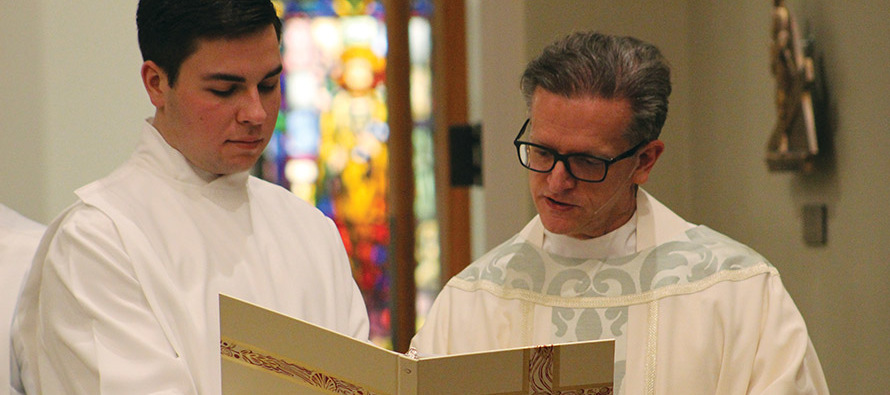 Father Paul English, C.S.B. reviews material prior to a liturgy.