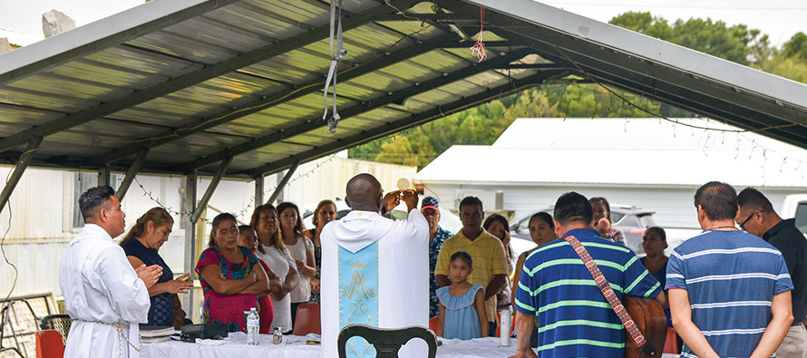 Glenmary Home Missioners celebrate Mass with migrant workers in a carport