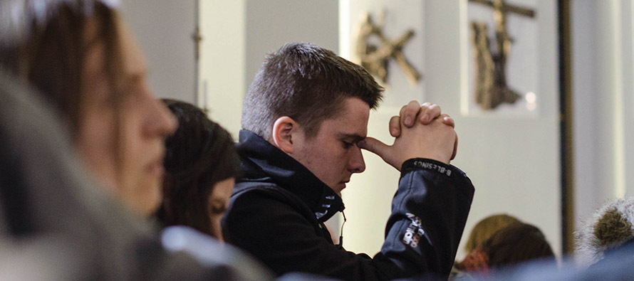young man praying in church