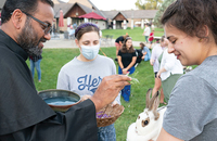 Friar George Munjanattu, O.F.M.Conv., a campus minister at Bellarmine University, blesses a university student’s rabbit on the Feast of St. Francis of Assisi.