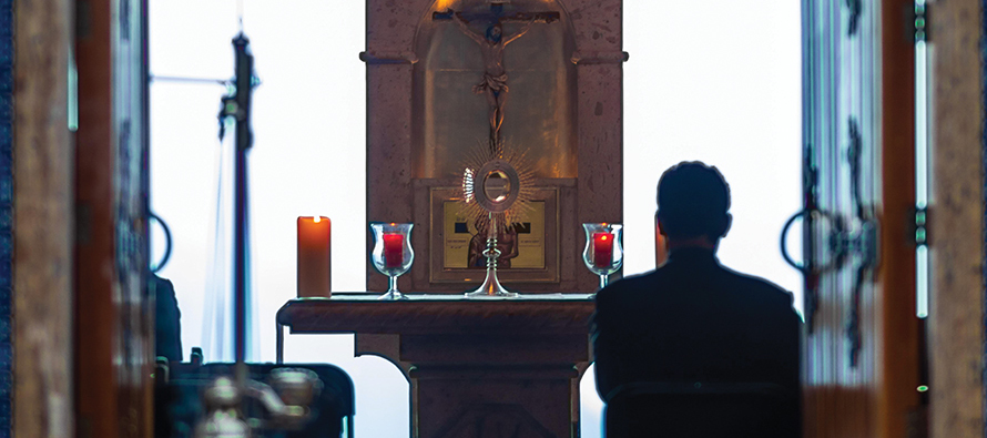 Man praying before a church altar