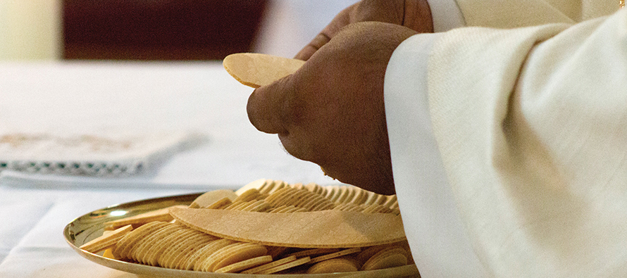 hands holding the Eucharist at an altar